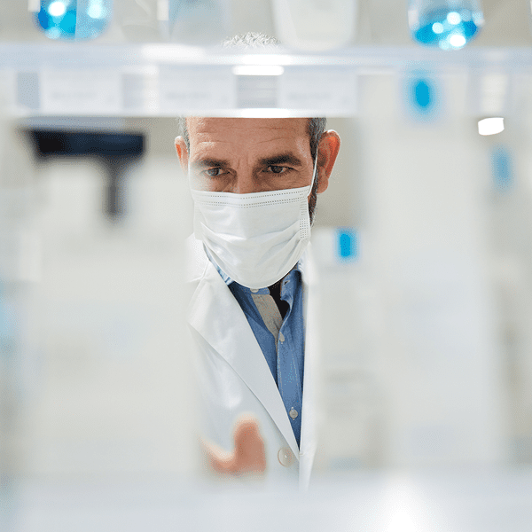Scientist in lab coat examining samples.