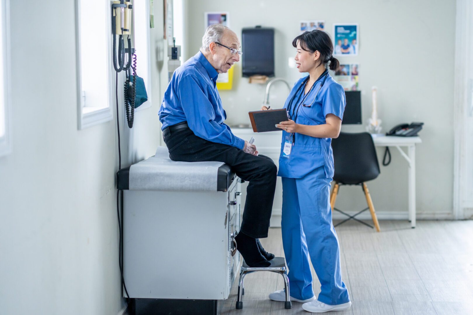 Doctor consulting with elderly patient in clinic.