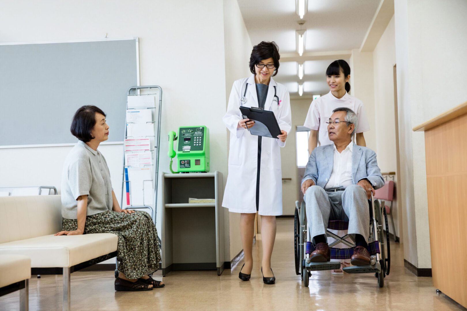 Doctor consulting patient in hospital hallway.